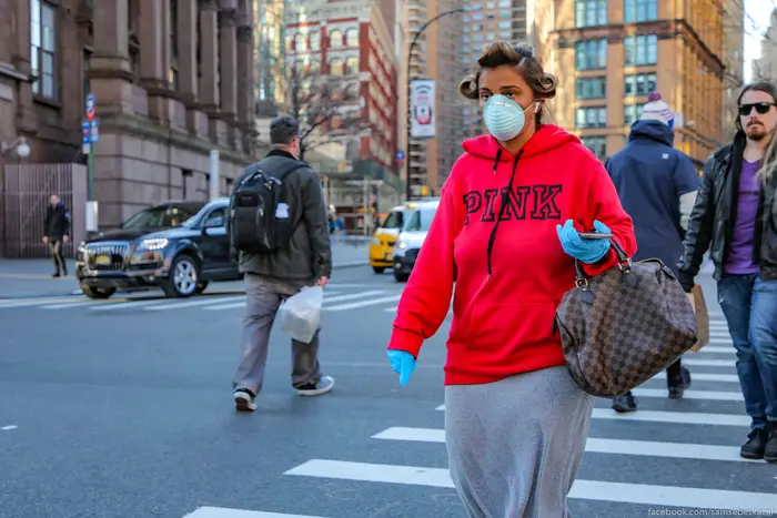 A photo of a woman walking in Manhattan with a mask on